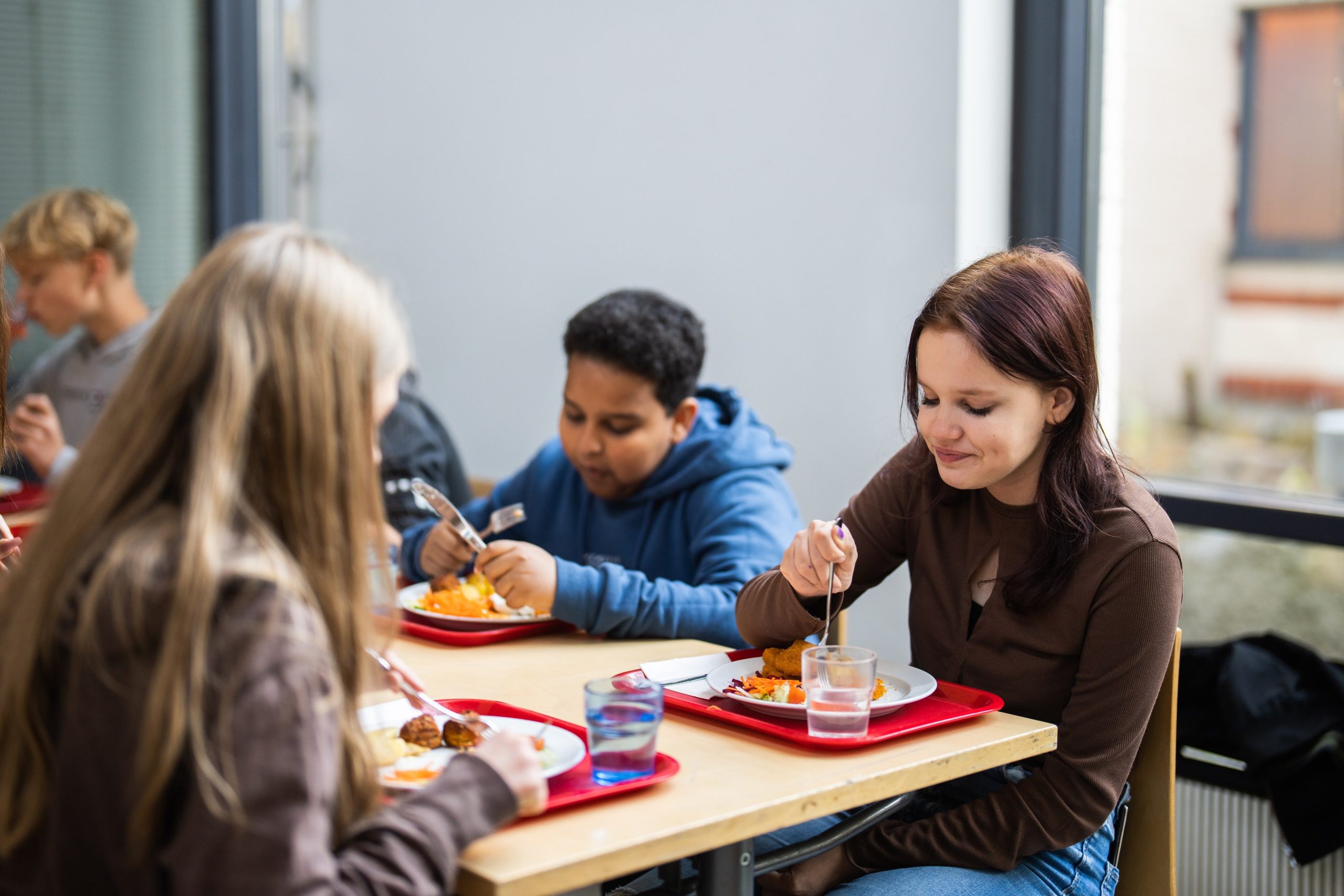 Oppilaita syömässä lounasta kouluruokalassa